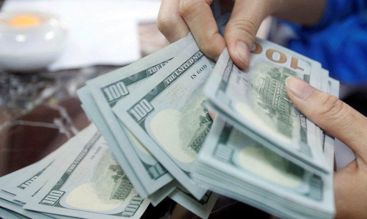 Dólar fecha abaixo de R$ 5, e bolsa cai com cautela global